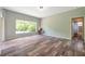Bright living room features wood floors, a large window, and an open doorway to the bathroom at 10925 Oyster Bay Cir, New Port Richey, FL 34654