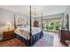 Bedroom features a four-poster bed, chandelier and a view of the landscaped yard at 11505 Cerca Del Rio, Temple Terrace, FL 33617