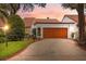 Charming home featuring a well-manicured lawn, warm-toned garage door, and welcoming curb appeal at 11505 Cerca Del Rio, Temple Terrace, FL 33617