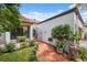 Charming home entrance with a brick path, iron gate, and lush landscaping at 11505 Cerca Del Rio, Temple Terrace, FL 33617