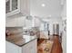 Spacious kitchen features stainless steel appliances, custom cabinets and hardwood flooring with colorful area rug at 11505 Cerca Del Rio, Temple Terrace, FL 33617