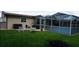 Backyard featuring a screened in patio, lounge chairs, and well-maintained grass at 11810 Oceanside Dr, Port Richey, FL 34668