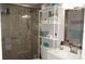Bathroom with tiled shower, grab bar, shelving, and vanity at 11810 Oceanside Dr, Port Richey, FL 34668
