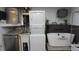 Laundry room with stacked washer/dryer, utility sink, and pet washing station at 11810 Oceanside Dr, Port Richey, FL 34668