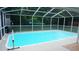 The screened-in pool area offers ample space for relaxation and recreation, with green trees in the backyard at 11810 Oceanside Dr, Port Richey, FL 34668