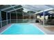 Spacious screened-in pool and patio featuring an outdoor dining set for comfortable entertaining and relaxation at 11810 Oceanside Dr, Port Richey, FL 34668