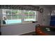 View of a refreshing pool through windows with a decorative valance at 11810 Oceanside Dr, Port Richey, FL 34668