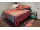 Bedroom with colorful bedding, patterned rug, and side table; relaxing, cozy atmosphere at 1231 Etta Ave, Spring Hill, FL 34609