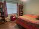 Bedroom with floral curtains and a colorful quilt on the bed next to the built-in shelves at 1231 Etta Ave, Spring Hill, FL 34609