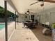 Outdoor patio with a pool, covered area with dining set, and lush landscaping at 1231 Etta Ave, Spring Hill, FL 34609