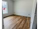Bright bedroom with wood-look flooring, white walls and a window providing ample natural light at 14586 Mocking Wren Rd, Weeki Wachee, FL 34614