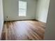 Spacious bedroom with wood-look flooring, white walls and a large window at 14586 Mocking Wren Rd, Weeki Wachee, FL 34614