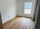 Bright bedroom with light wood-look flooring, large window, and white walls at 14586 Mocking Wren Rd, Weeki Wachee, FL 34614