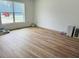 Spacious bedroom showcasing light wood-look flooring, a large window and white walls at 14586 Mocking Wren Rd, Weeki Wachee, FL 34614