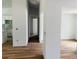 Hallway with wood-look flooring connecting various rooms of the house with white walls at 14586 Mocking Wren Rd, Weeki Wachee, FL 34614