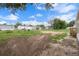 Backyard showing grass, dirt, mobile homes, storage, and wooded backdrop at 16104 Naples St, Brooksville, FL 34604