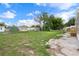 View of the backyard showing the grass, shed, mobile home, and wooded backdrop at 16104 Naples St, Brooksville, FL 34604