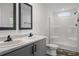 Bathroom features dual sinks, gray vanity, framed mirrors, and a bright white walk-in shower at 16104 Naples St, Brooksville, FL 34604