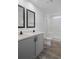 Bright bathroom featuring a double vanity, framed mirrors, and a shower with white tile surround at 16104 Naples St, Brooksville, FL 34604