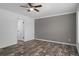 Bedroom with a neutral gray accent wall, wood-look floors, a ceiling fan, and white trim at 16104 Naples St, Brooksville, FL 34604