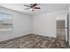 Bedroom with wood-look floors, white walls and trim, and a large window with a view at 16104 Naples St, Brooksville, FL 34604