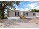 Single-story home features tan siding, black shutters and wood stairs at 16104 Naples St, Brooksville, FL 34604