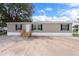 Tan siding with white trim accents a single-story home at 16104 Naples St, Brooksville, FL 34604