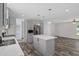 Bright kitchen features a gray island, stainless appliances, white counters, and modern pendant lighting at 16104 Naples St, Brooksville, FL 34604