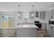 Bright kitchen features white counters, a center island, gray cabinetry, and a sliding glass door at 16104 Naples St, Brooksville, FL 34604