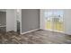 Welcoming living space featuring wood-style floors, access to a bathroom, and sliding glass doors to the outside at 16104 Naples St, Brooksville, FL 34604