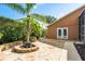 Private backyard featuring a fire pit on a stone patio and lush landscaping at 1831 Cardamon Dr, Trinity, FL 34655