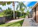 Green backyard with brick pathway, gravel, and well-maintained landscaping at 1831 Cardamon Dr, Trinity, FL 34655