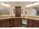 Bathroom featuring double vanity, granite countertops, and decorative mirrors at 1831 Cardamon Dr, Trinity, FL 34655
