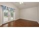 Bedroom features wood floors and french doors to outdoor space with blue curtains at 1831 Cardamon Dr, Trinity, FL 34655