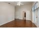 Bedroom with wood floors has white closet doors and french doors with blue curtains at 1831 Cardamon Dr, Trinity, FL 34655