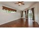 Bright bedroom with hardwood floors, ceiling fan, and sliding glass doors leading to the pool area at 1831 Cardamon Dr, Trinity, FL 34655