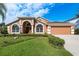 Charming, single-story home featuring an arched entryway, manicured lawn, and two-car garage at 1831 Cardamon Dr, Trinity, FL 34655