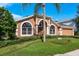 Charming home featuring arched windows, landscaped front yard, and a well-manicured lawn at 1831 Cardamon Dr, Trinity, FL 34655