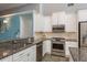 Well-equipped kitchen with stainless steel appliances, granite countertops, and white cabinetry at 1831 Cardamon Dr, Trinity, FL 34655