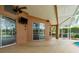 A view of the pool and lanai with a mounted television, ceiling fan, and sliding glass doors at 1831 Cardamon Dr, Trinity, FL 34655