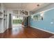 Bright living room featuring hardwood floors, blue accent wall, and sliding glass doors to the pool at 1831 Cardamon Dr, Trinity, FL 34655