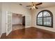 Sun-filled living room boasting hardwood floors, a ceiling fan, and a lovely arched window at 1831 Cardamon Dr, Trinity, FL 34655