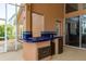 Outdoor kitchen featuring a built-in grill, blue tiled counter, and a mini fridge at 1831 Cardamon Dr, Trinity, FL 34655