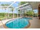 An in-ground pool is surrounded by a screened-in lanai and professional landscaping at 1831 Cardamon Dr, Trinity, FL 34655