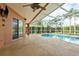 A screened in lanai with a beautiful in-ground swimming pool and tropical landscaping at 1831 Cardamon Dr, Trinity, FL 34655