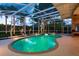 Screened-in pool with spa features, surrounded by tropical landscaping and ample patio space at 1831 Cardamon Dr, Trinity, FL 34655