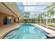 A private in-ground swimming pool is surrounded by a screened lanai and professional landscaping at 1831 Cardamon Dr, Trinity, FL 34655