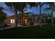 Exterior view of a screened-in pool area with outdoor lighting and mature palm trees at 1831 Cardamon Dr, Trinity, FL 34655