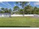 Spacious backyard with mature trees and lush lawn, featuring a storage shed and a privacy fence at 2027 Fentress Ct, Spring Hill, FL 34609