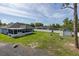 Spacious backyard with a lush lawn, shed, and white privacy fence, offering ample space for outdoor activities at 2027 Fentress Ct, Spring Hill, FL 34609